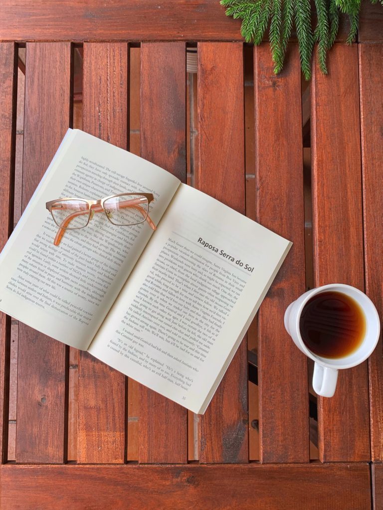Ilko Mivev's book In the Shadow of the Lost World on a table with a cup of tea and glasses.